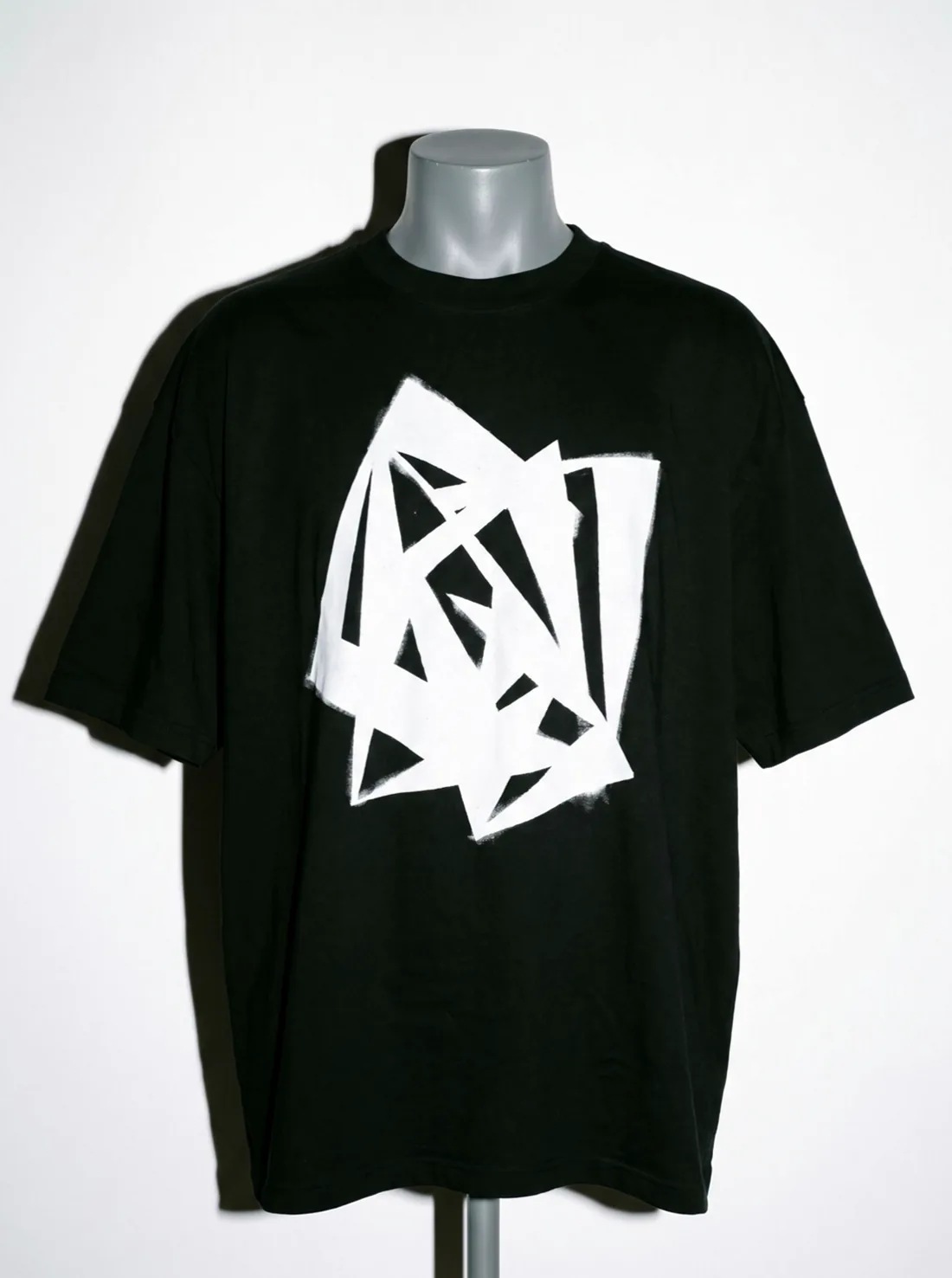 The Kerb tee, front on, its white abstract print square to camera, frame one of its turn