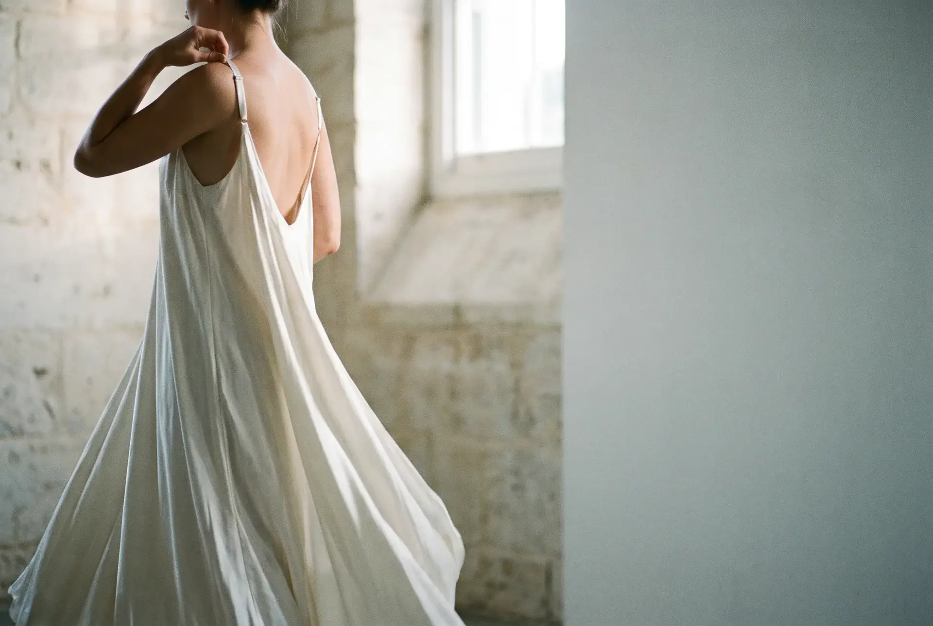 Hero photograph: a single figure in raked afternoon light against a limestone wall.